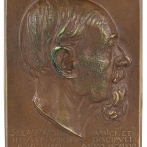 Plakietka przed konserwacją, z widocznymi śladami korozji.